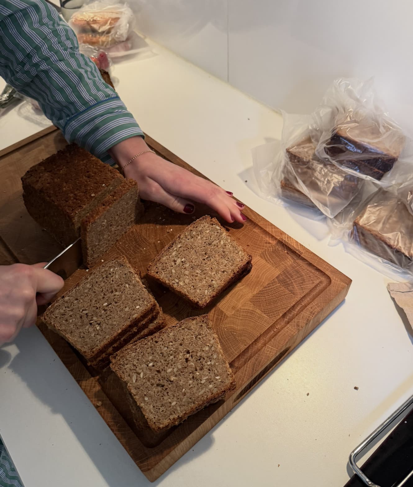 Sliced loaf of dark, seed-packed Danish rye bread on a cutting board